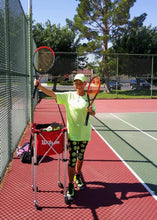 Load image into Gallery viewer, Woman wearing the Hit Happy Tennis Capri Leggings on the tennis court