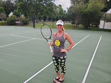 Load image into Gallery viewer, Woman wearing the Hit Happy Tennis Capri Leggings and tank top on the tennis court