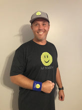 Load image into Gallery viewer, A man wearing the Hit Happy Tennis- Men&#39;s Next Level Triblend T-Shirt, hat, and wristband
