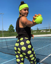 Load image into Gallery viewer, Woman wearing the Hit Happy Tennis Capri Leggings on the tennis court
