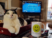 Load image into Gallery viewer, Enjoying coffee in the Hit Happy Tennis Coffee Mug while watching Tennis with my pet cat
