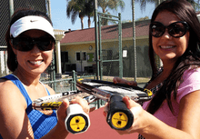 Load image into Gallery viewer, Two women holding tennis racquets on the tennis court with our funny Tennis Butt Decals - "Naughty or Nice"