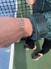 Load image into Gallery viewer, Woman wearing the Queen of the Court bracelet for tennis players on the tennis court
