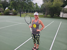 Load image into Gallery viewer, Woman wearing the Hit Happy Tennis Capri Leggings and tank top on the tennis court
