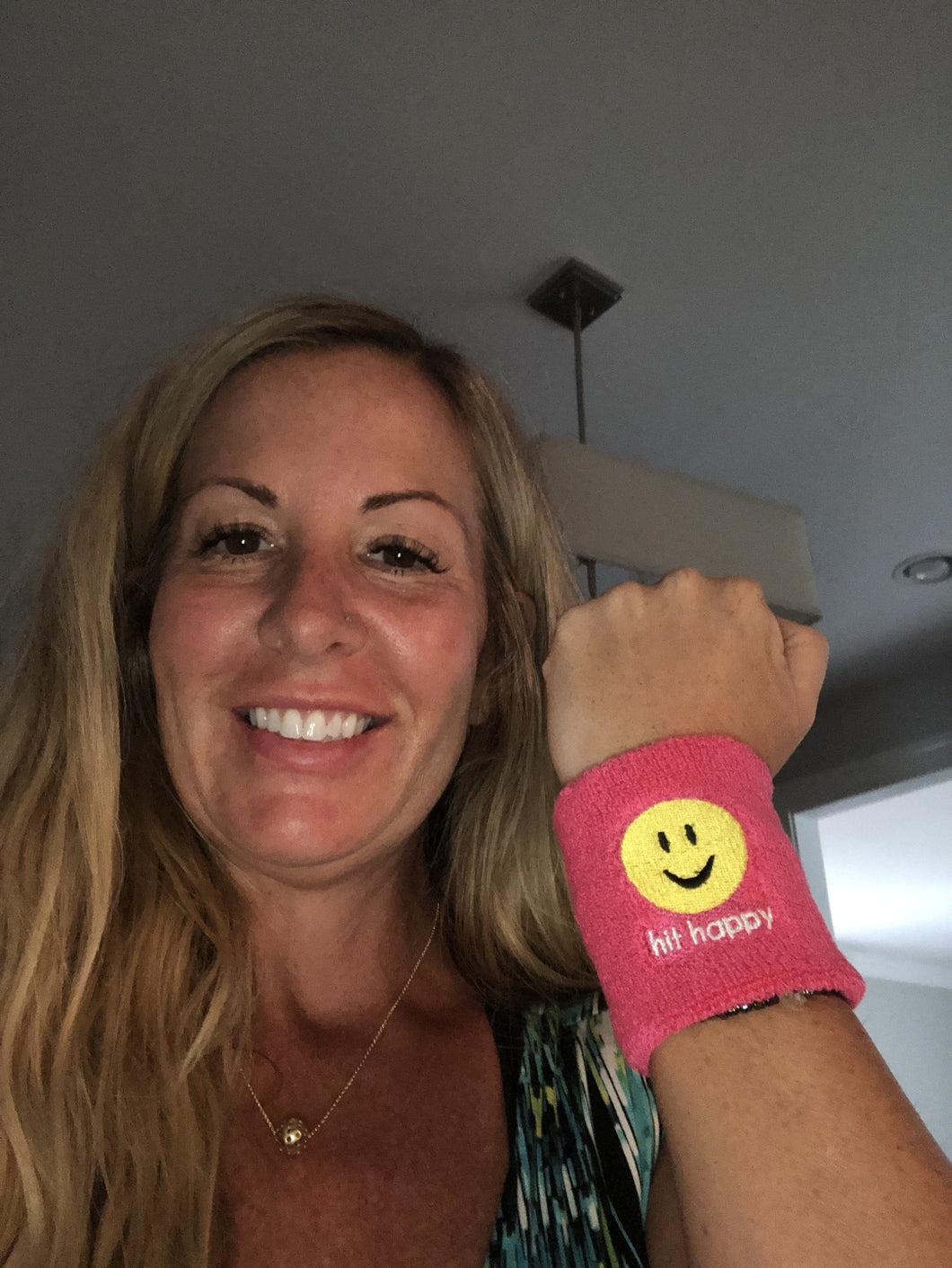 A woman wearing a pink Hit Happy Tennis Wristband